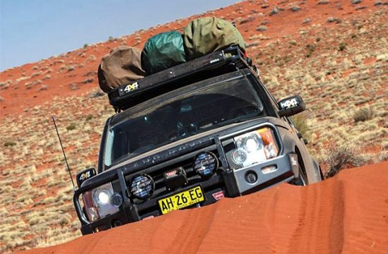 Range Rover Discovery with Tradesman Oval Steel roof rack on a red sand dune in outback Australia.